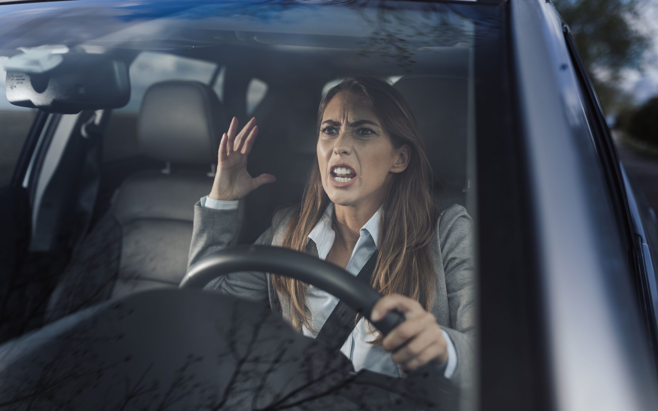 Angry business woman yelling in car